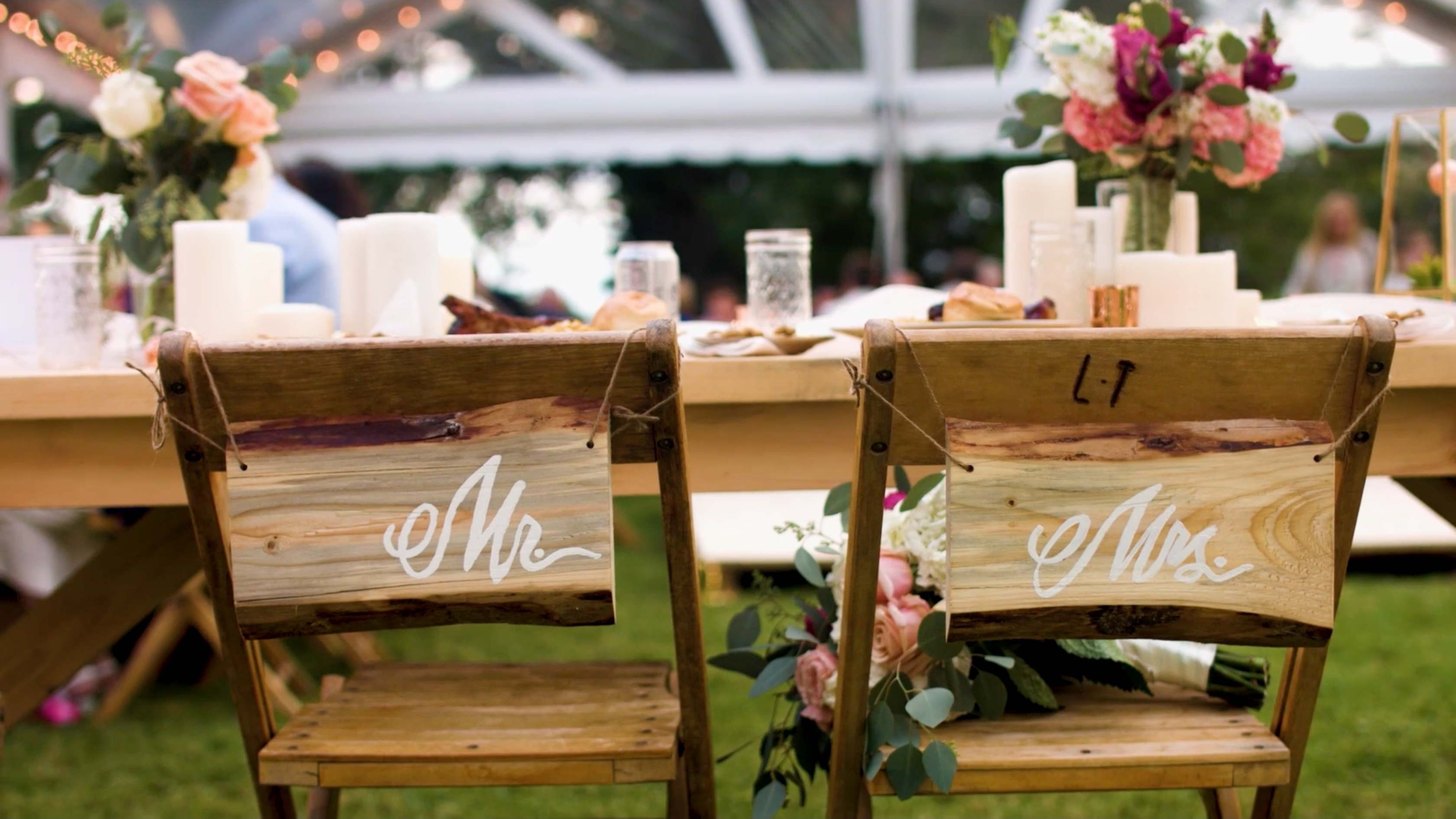 Rustic wooden Mr and Mrs chair signs at a candlelit reception table